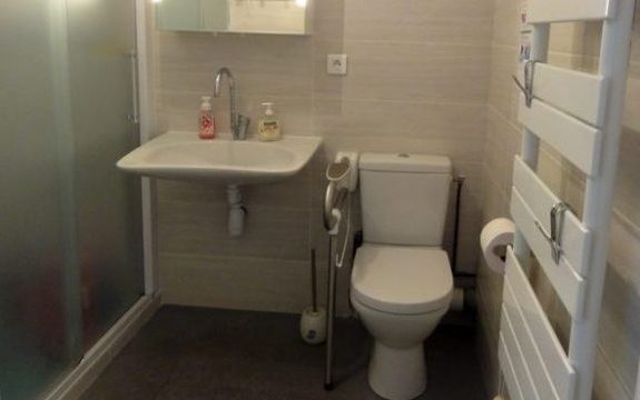 Après les travaux: Le lavabo Handilav, à faible encombrement, facilite l'utilisation d'un fauteuil roulant. La poignée de maintien rabattable sécurise l'accès au WC