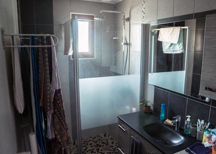 Au fond de la salle d'eau, la fenêtre éclaire toute la pièce grâce au vitrage de la douche